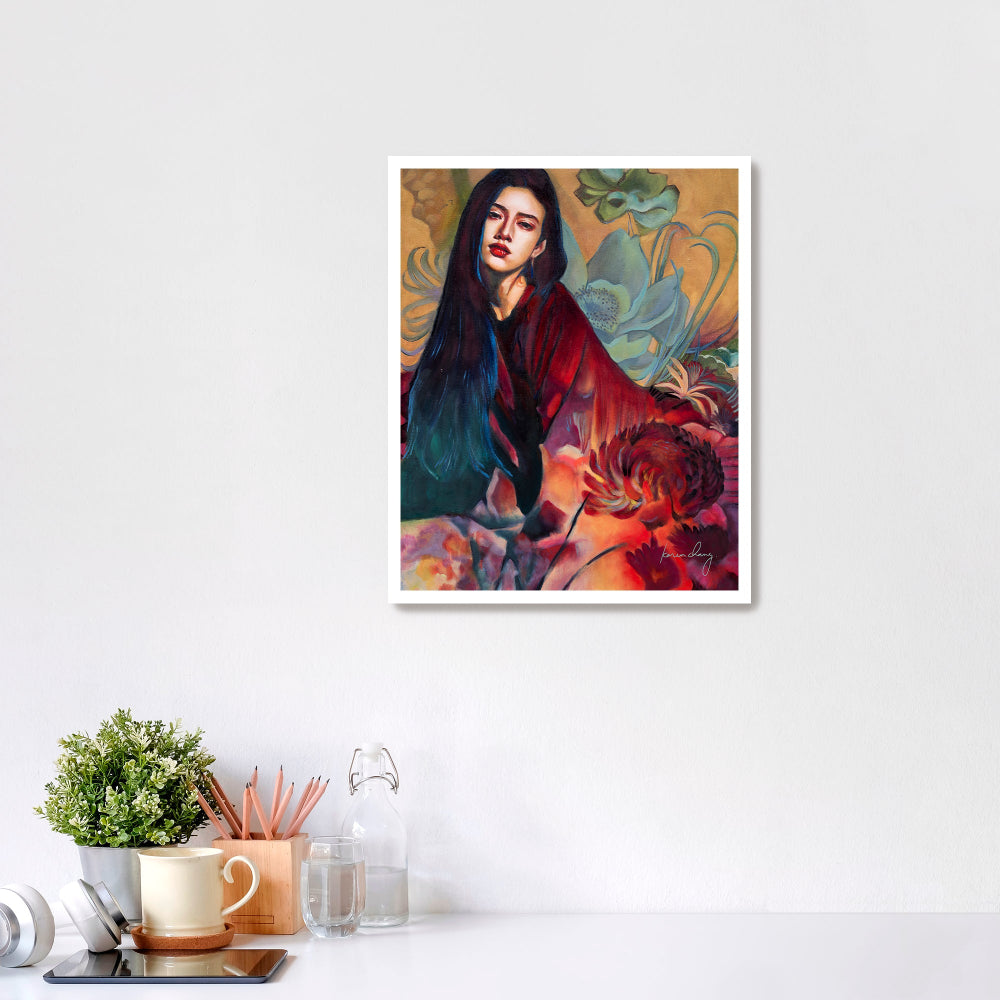 Framed artwork of a woman with flowers on a white wall above a desk.