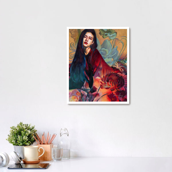 Framed artwork of a woman with flowers on a white wall above a desk.