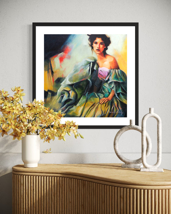 Framed artwork of a woman in a green dress on a wall above a wooden console table with decorative items.