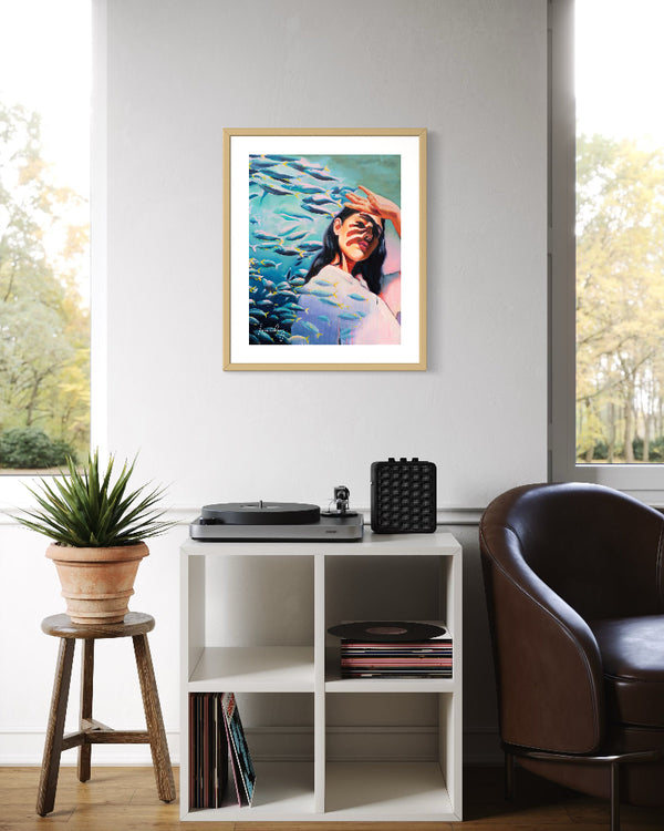 Framed artwork of a woman in a pool on a wall above a record player and records.