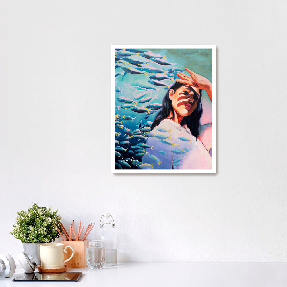 Framed artwork of a woman surrounded by fish on a white wall.