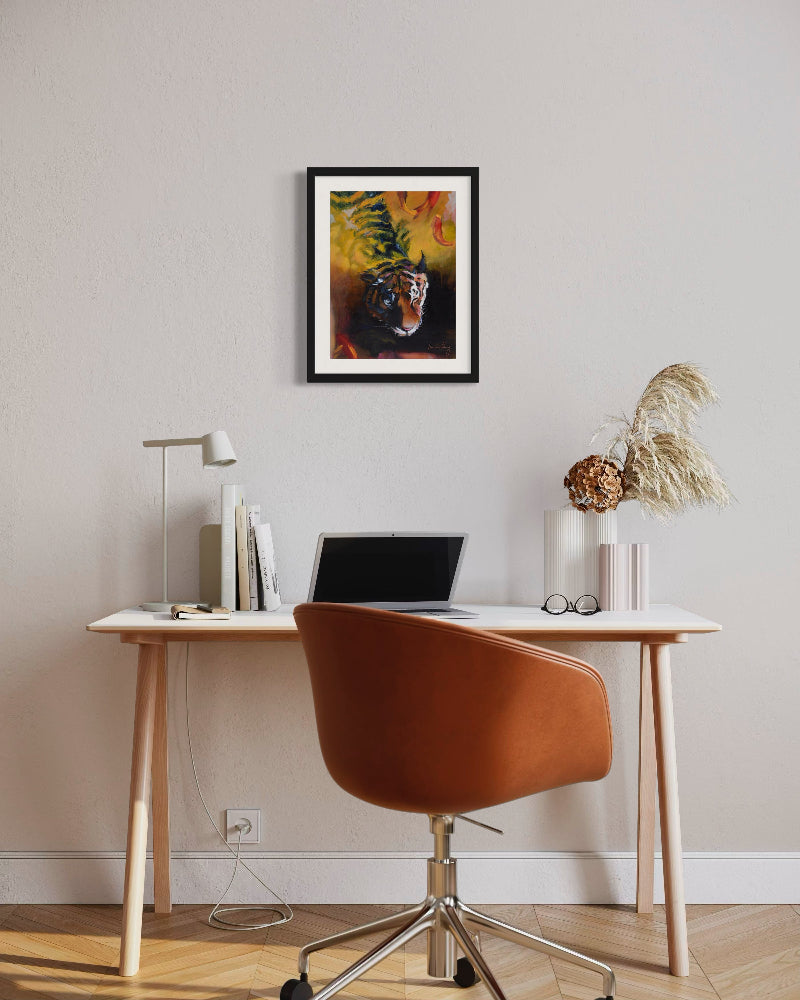 Modern home office with a desk, chair, laptop, and framed artwork on the wall.