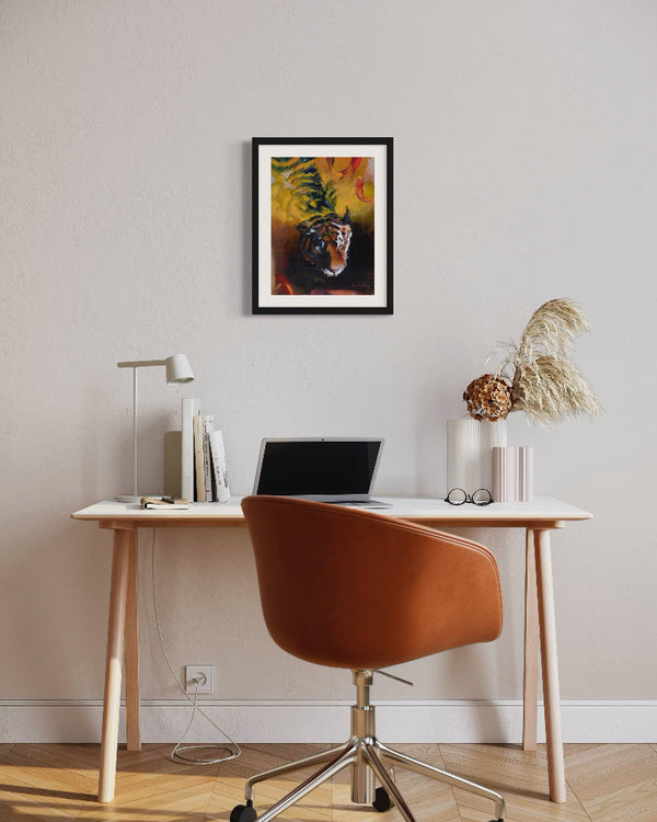 Modern home office with a desk, chair, laptop, and framed artwork on the wall.