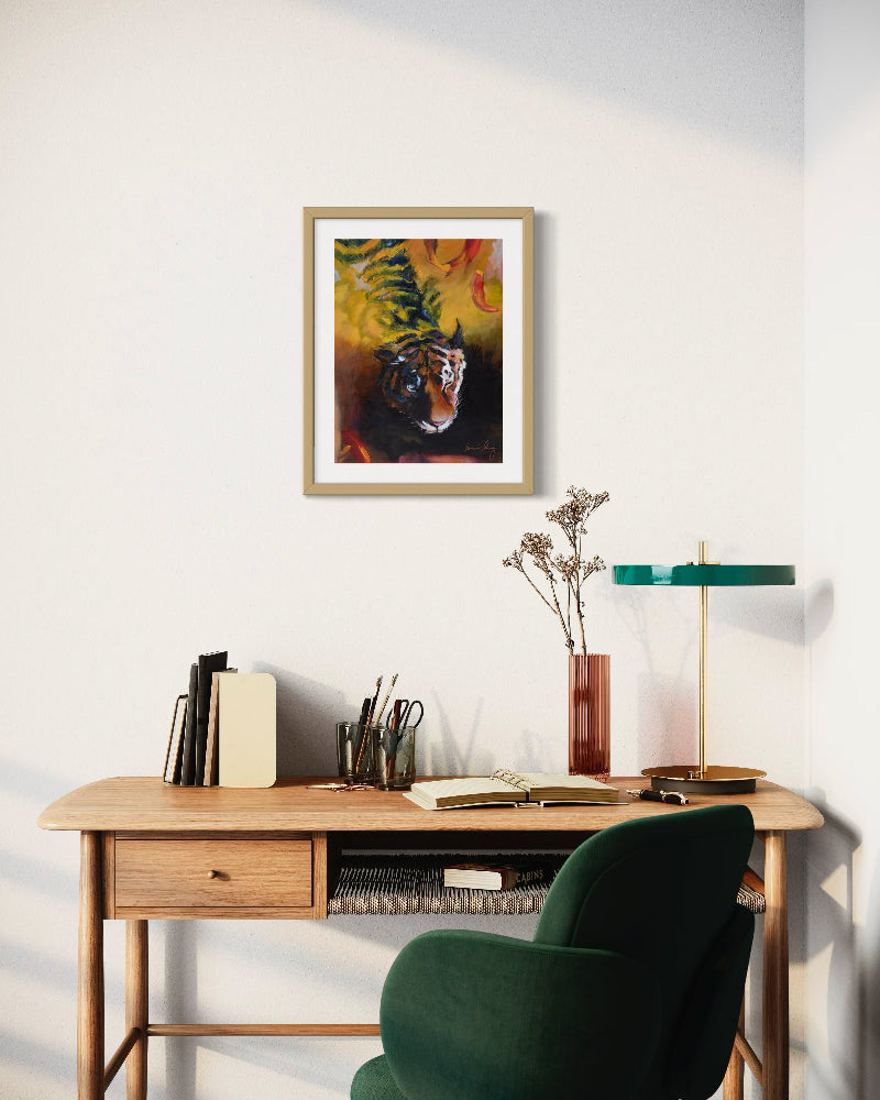Home office with wooden desk, green chair, and framed artwork on the wall.