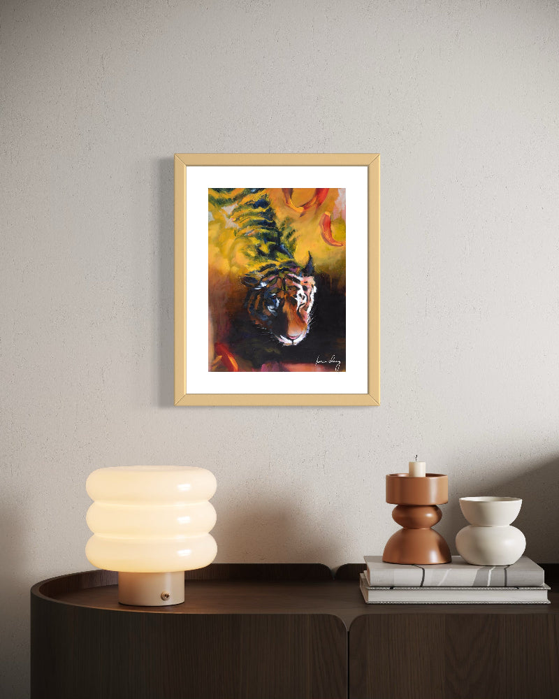 Framed artwork of a tiger on a wall above a side table with decorative items.