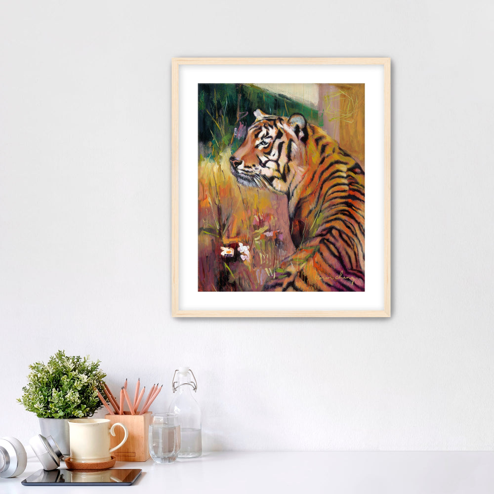 Framed artwork of a tiger on a wall above a desk with office supplies.