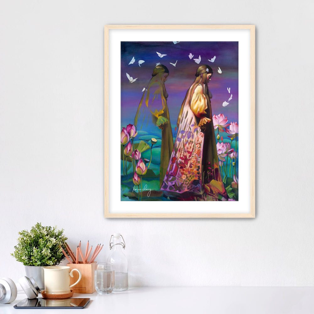 Framed artwork of two people in a garden with flowers and butterflies on a white wall.