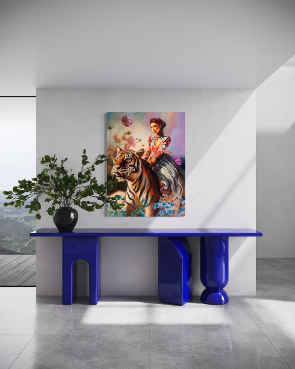 Modern interior with a blue console table, plant, and colorful painting of a woman with a tiger.