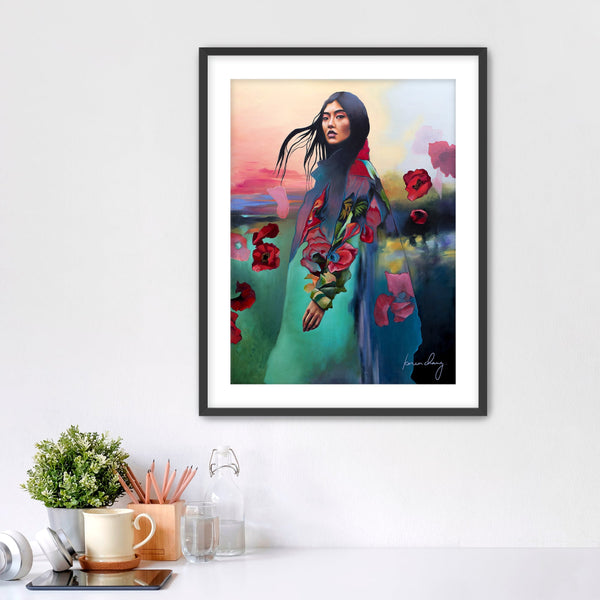 Framed artwork of a woman in a floral dress with a colorful background on a white wall.