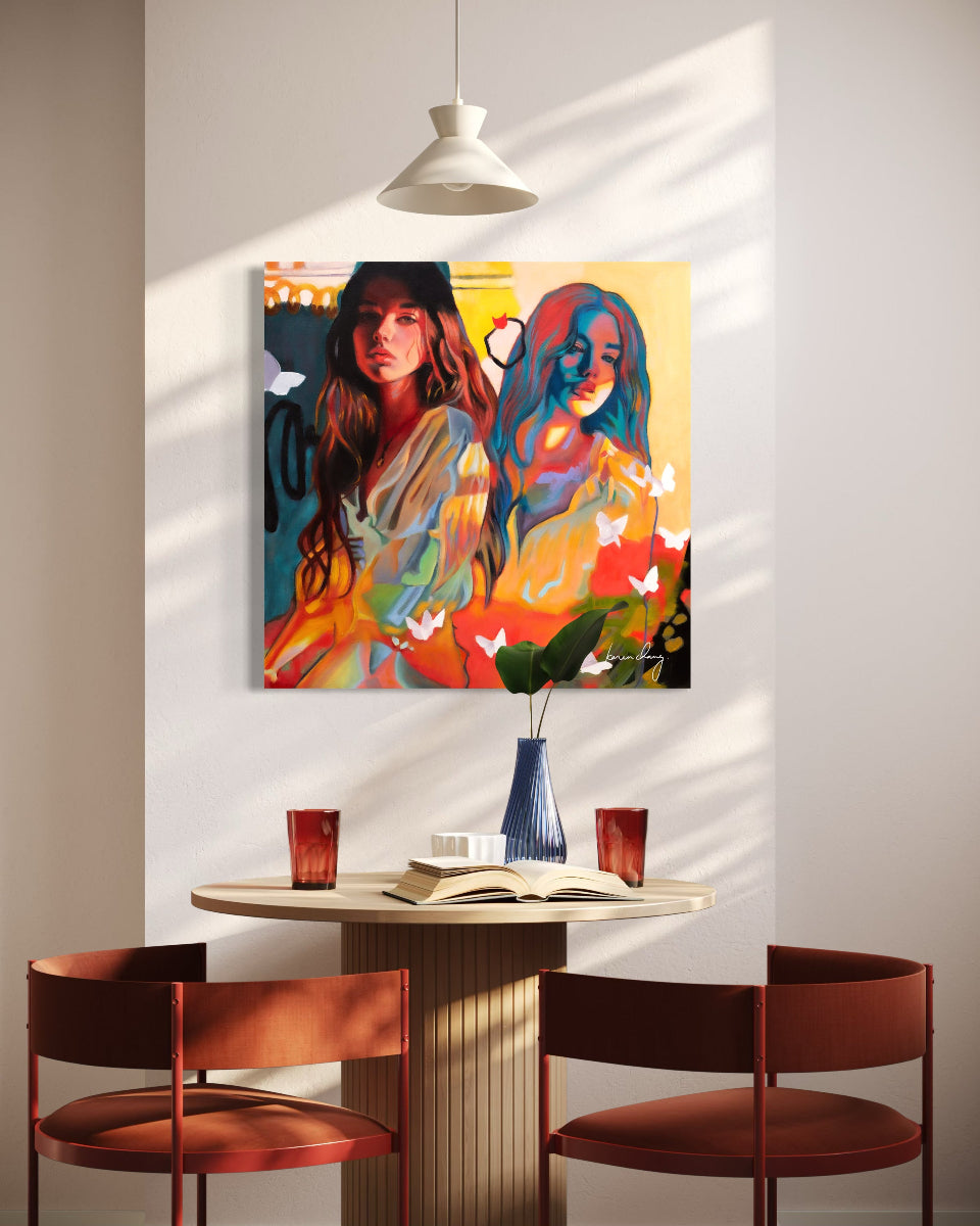 Colorful abstract painting of two women on a wall above a dining table with chairs.