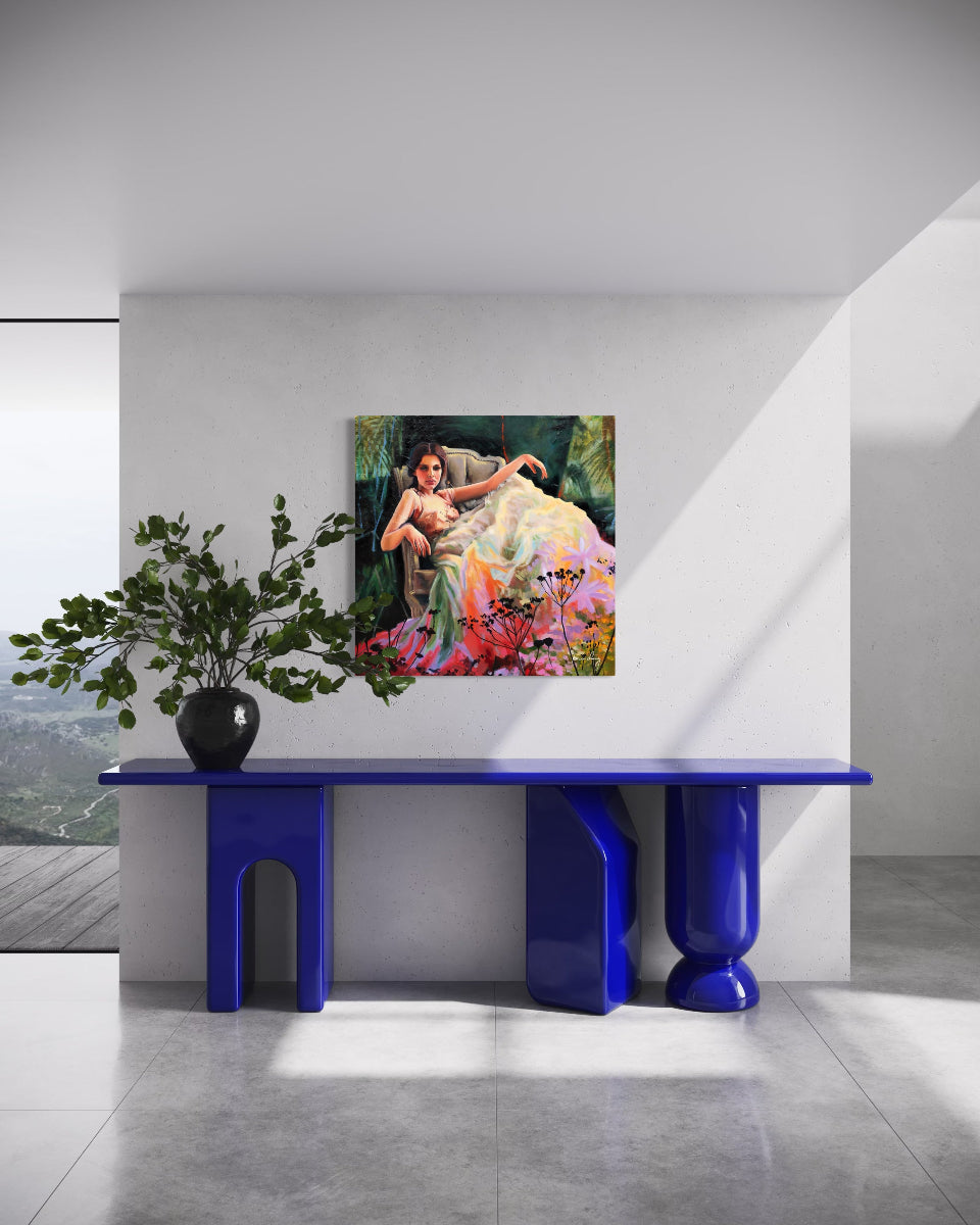 Modern interior with a blue console table, plant, and colorful painting on a white wall.