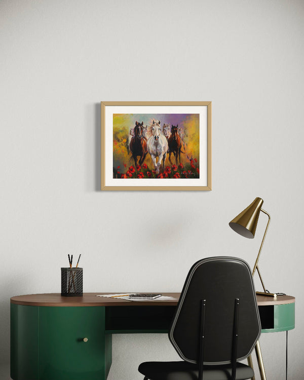 Framed artwork of horses on a wall above a desk with a chair and lamp.