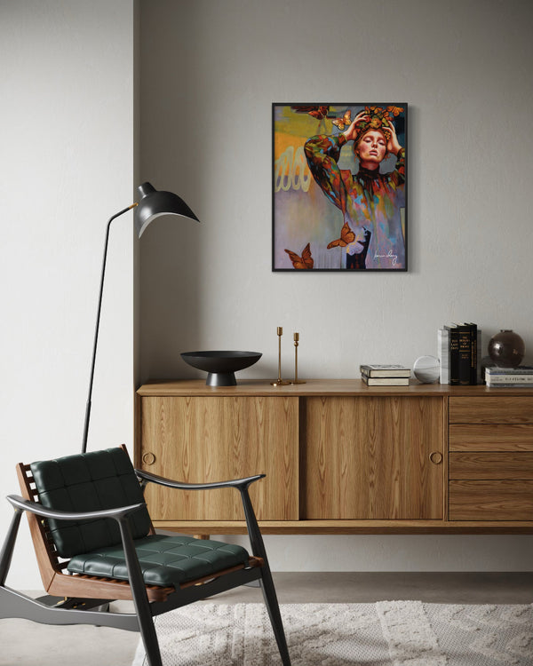 Modern living room with a wooden cabinet, black chair, and colorful artwork on the wall.