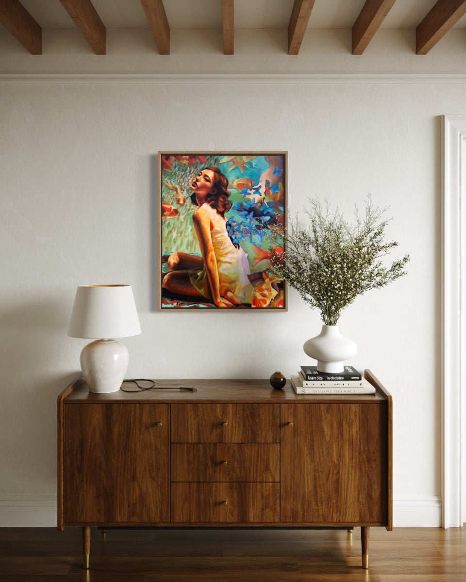 Wooden sideboard with a lamp, vase, and decorative items against a wall with a colorful painting.