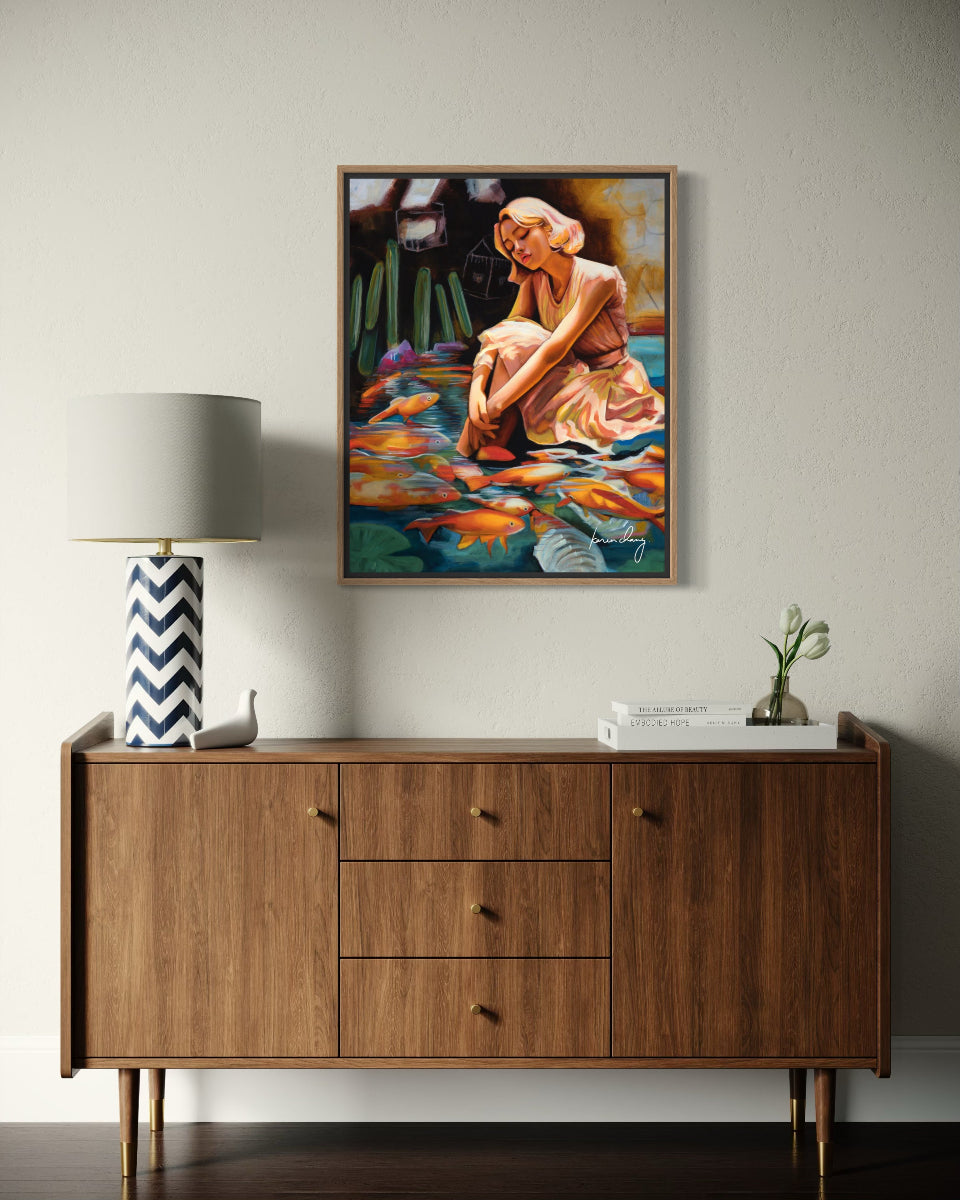 Wooden sideboard with a lamp, plant, and painting of a woman on a wall.