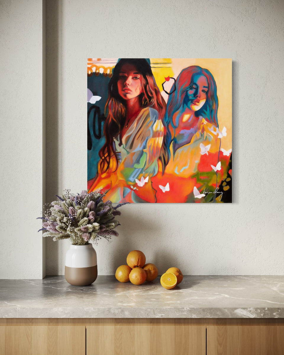 Colorful abstract painting of two women on a wall above a wooden shelf with decorative items.